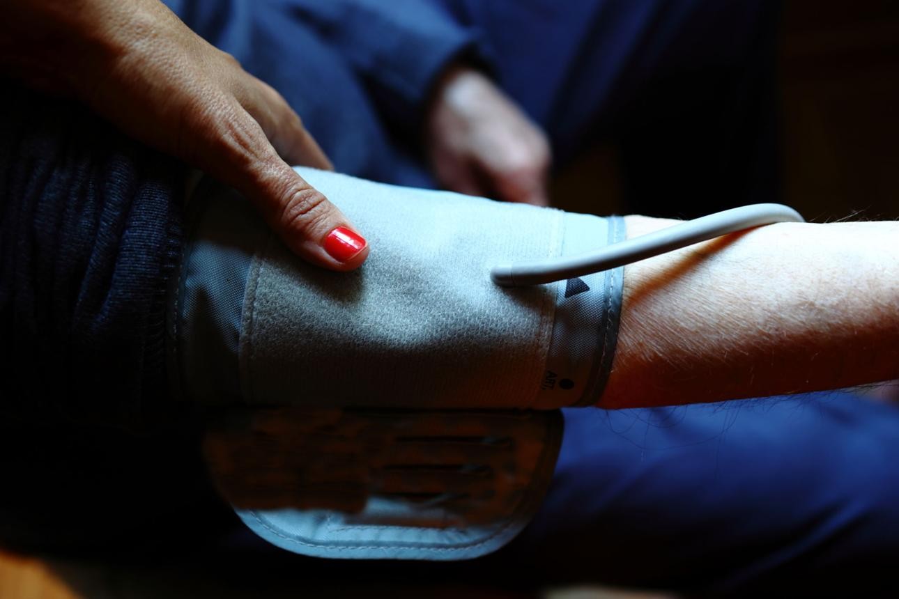 Home nurse checking vitals for a patient managing chronic conditions