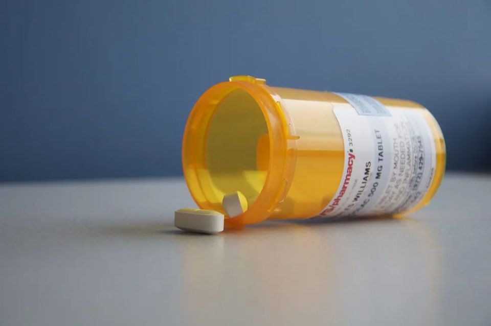A prescription medication bottle with pills, representing a home medication routine