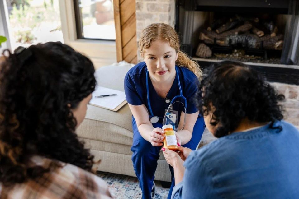 A nurse consulting with a client about medications in a comfortable home setting