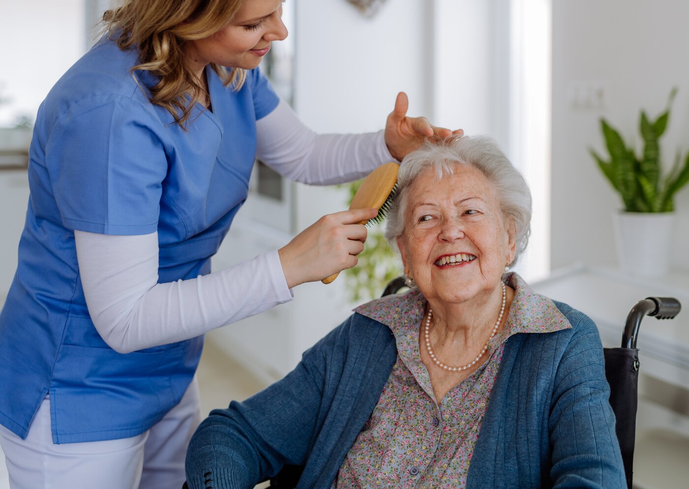 A caregiver with an ID badge sharing a warm moment with seniors and family members