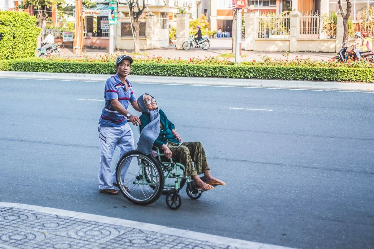 A caregiver assisting a senior who uses a wheelchair with mobility in the Fort Worth area
