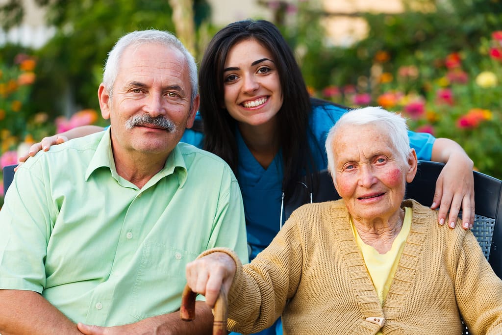 A home-care nurse visiting and supporting a senior couple at home