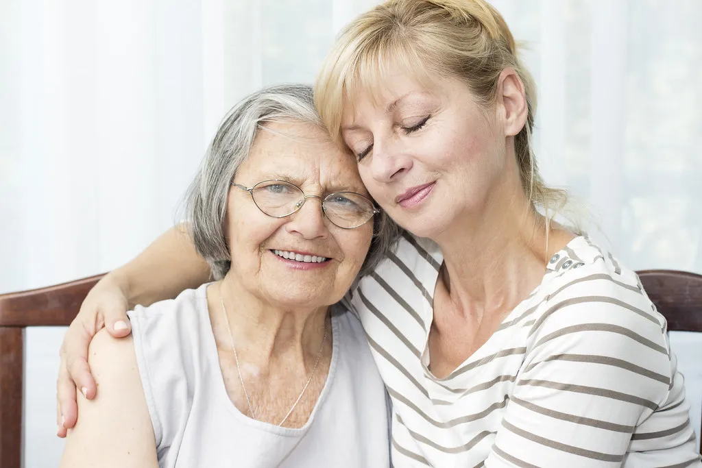 Compassionate moment of dignified care between a caregiver and a senior